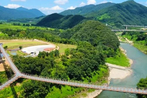 여름 한탄강 물길을 가로지르는 붉은 보도교와 둘러싼 산줄기
