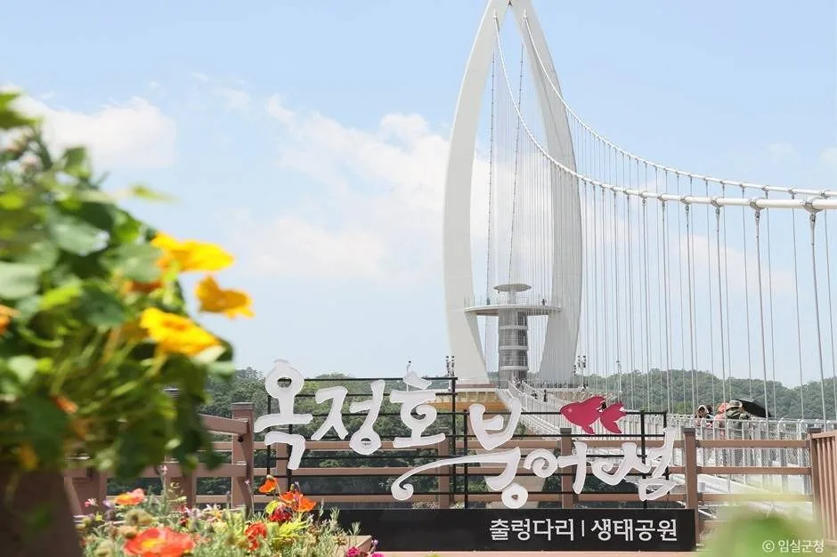 옥정호 붕어섬 출렁다리 표지판과 그 뒤로 보이는 붕어 모양 주탑