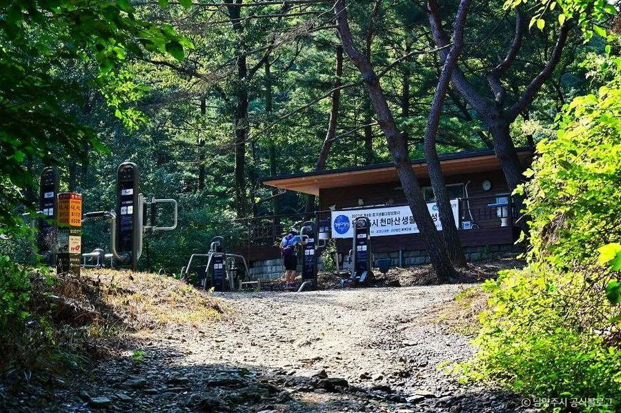 천마산 탐방로 초입의 쉼터 건물과 야외 운동기구