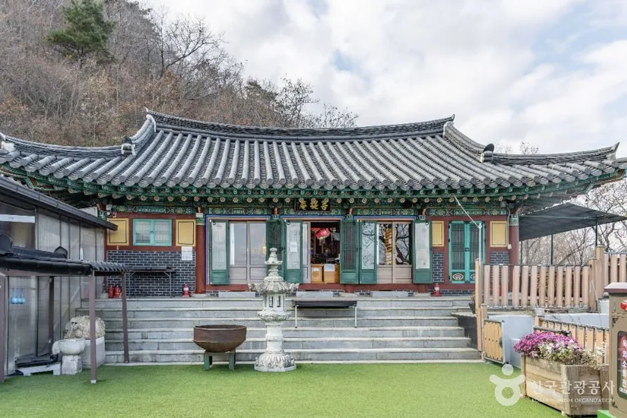 산비탈 위 좁은 마당에 앉은 보리암 법당의 기와지붕과 단청, 앞마당의 석등