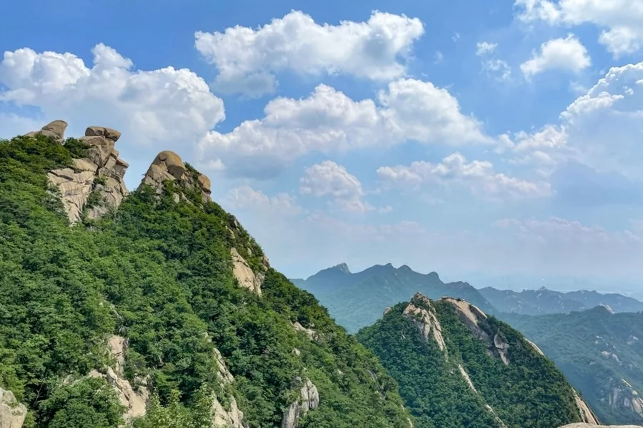Granite boulders on a Bukhansan ridge with wooded ridges behind