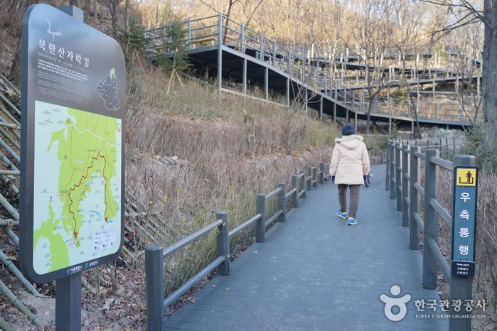 북한산 자락 나무데크 산책로를 걷는 사람