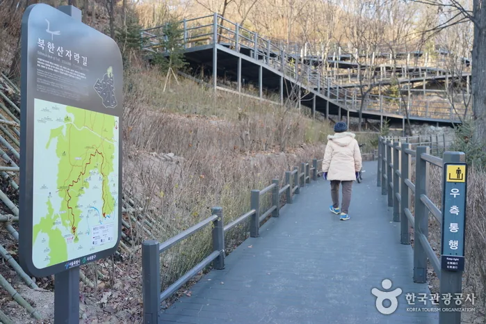북한산 자락 나무데크 산책로를 걷는 사람