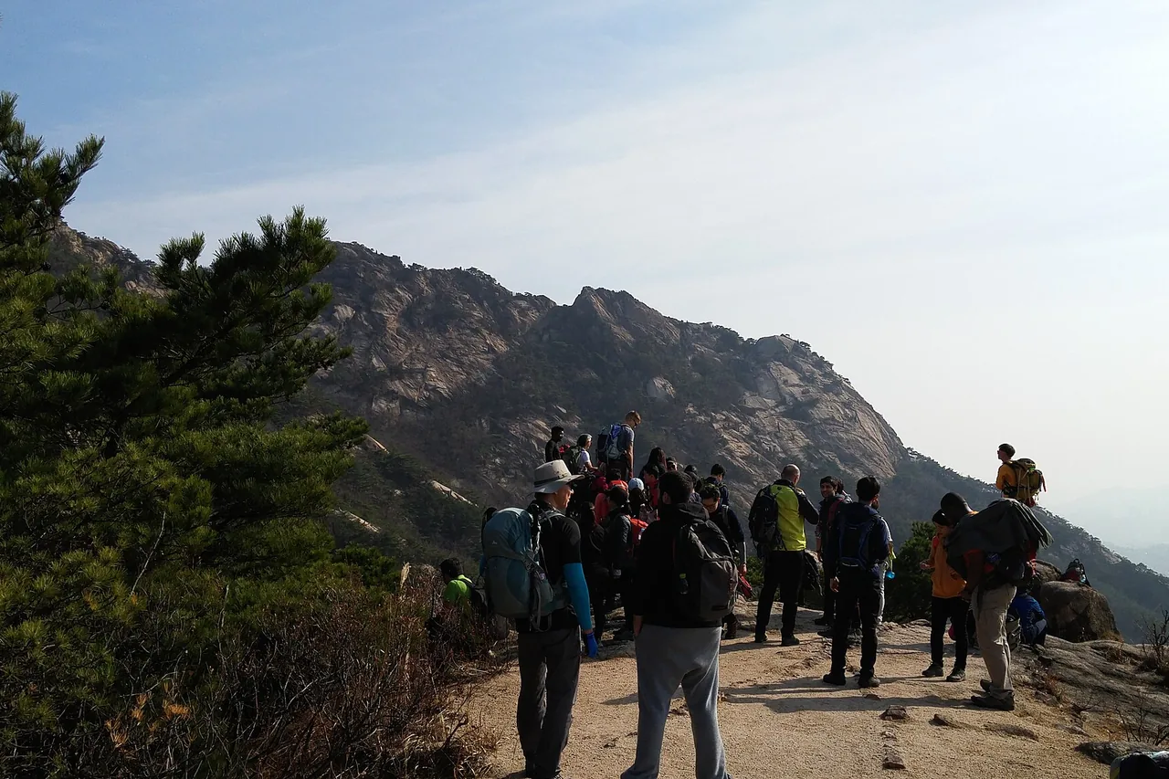 Hikers gathered on a Bukhansan ridge with Seoul below