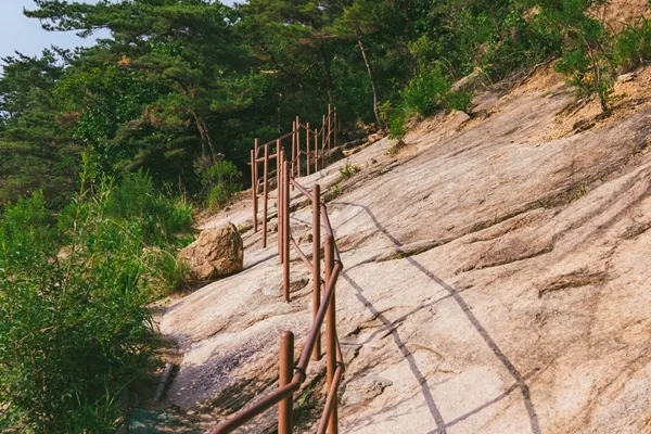 Steel handrails bolted into a bare granite slab on Bukhansan