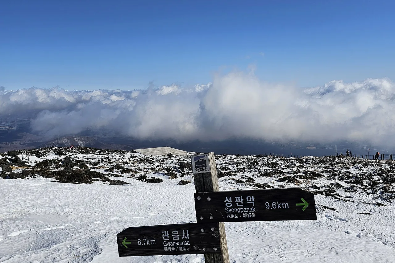 Signpost at the summit of Hallasan showing Seongpanak and Gwaneumsa distances