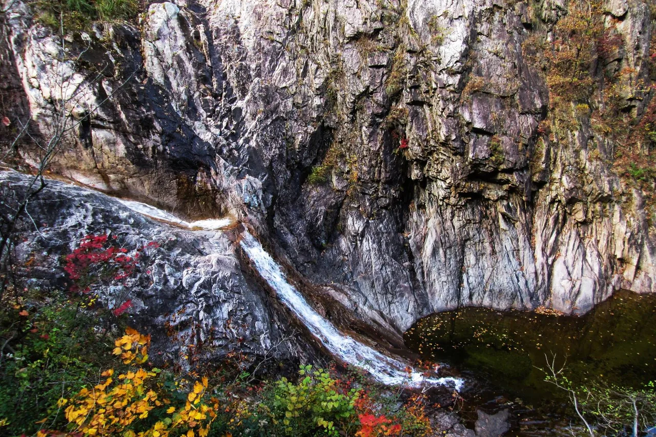Waterfall running down granite into a pool in a Seoraksan gorge in autumn